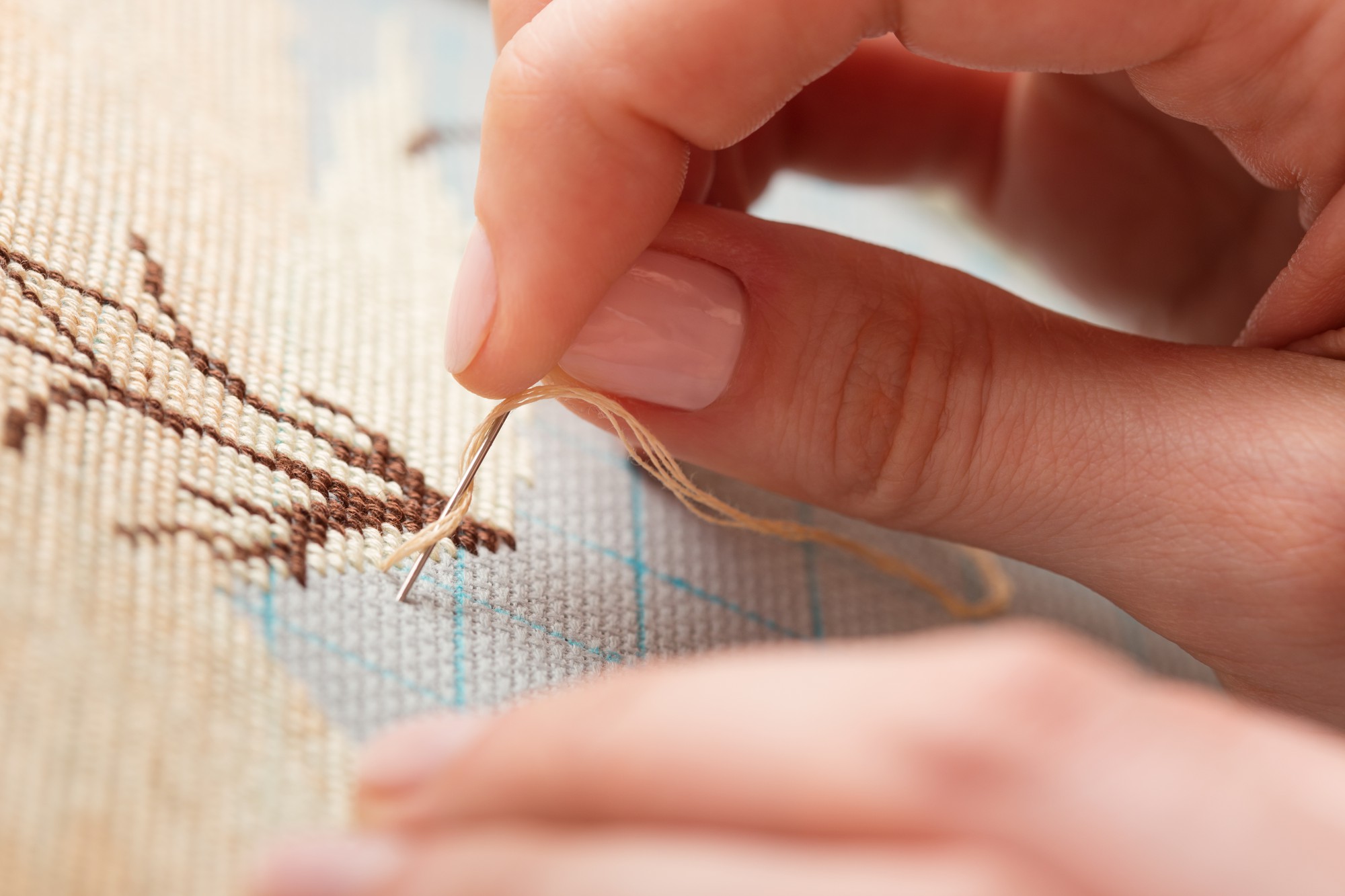 Instruktoriaus rankos siuvinėjant sudėtingą raštą
